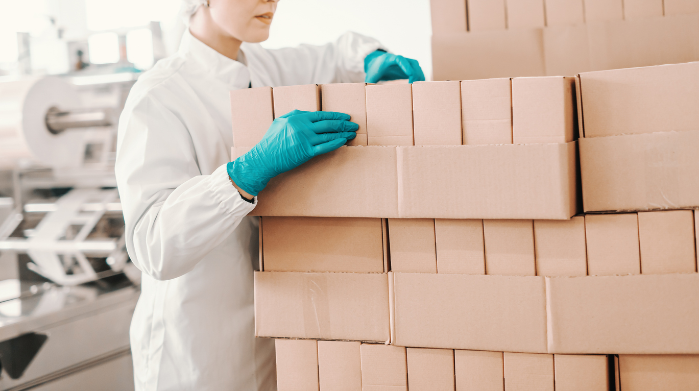 Employee counting boxes of porcine material in factory