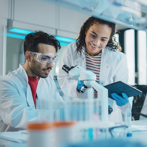Two scientists looking through microscope